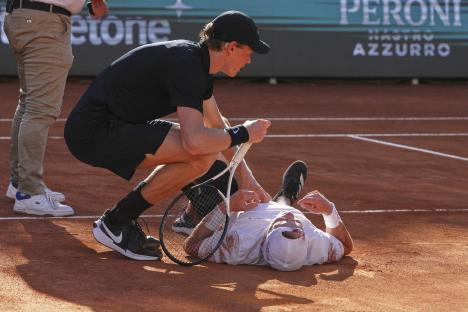 Jannik Sinner attending to Jesper De Jong who fell during a tennis match.