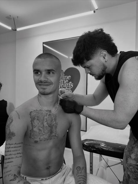 Romeo Beckham getting a new tattoo.