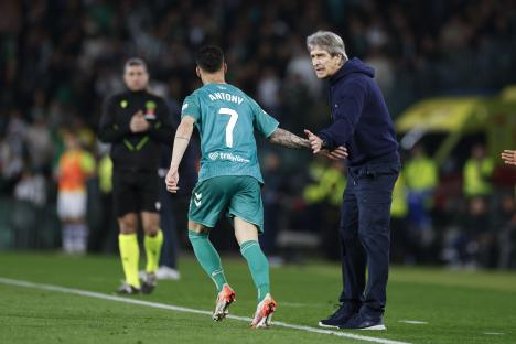 Real Betis' Antony Matheus celebrates with his coach after scoring a goal.