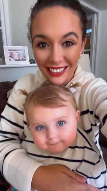 A woman smiling with her baby.