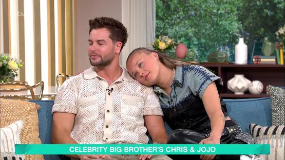 Chris Hughes and JoJo Siwa on a talk show sofa.