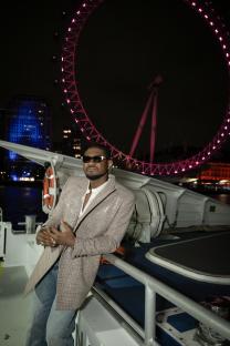 Usher on a boat in London, with the London Eye in the background.