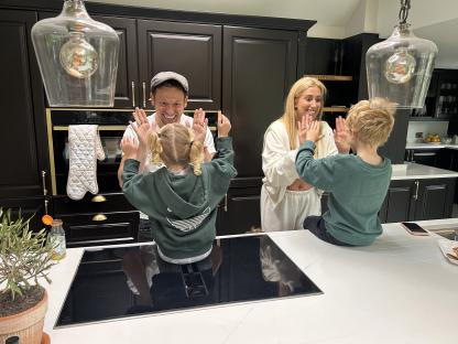 Family giving high fives in a kitchen.