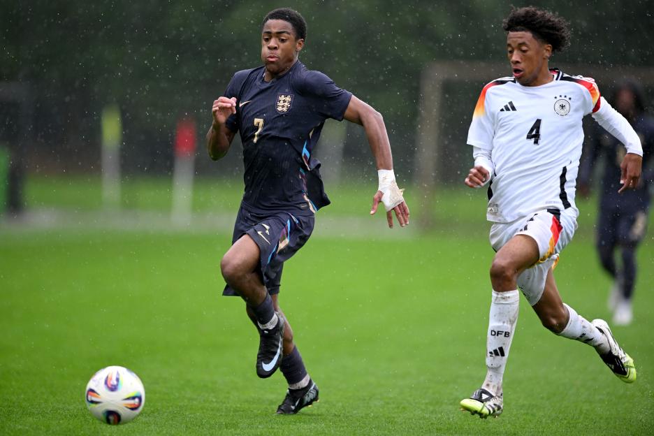Soccer players from England and Germany competing in a match.