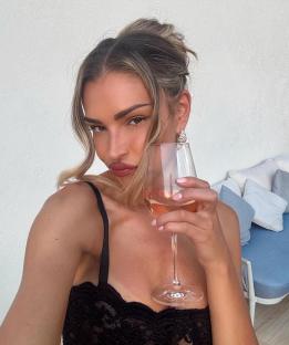 Woman holding a glass of rosÃ©.
