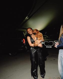 Woman holding a small brown dog.