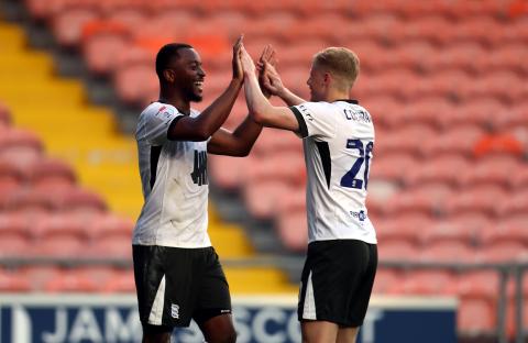 Two soccer players celebrating a goal.