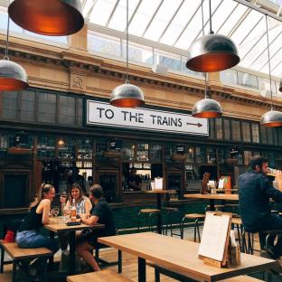 Market hall bar with patrons seated at tables.