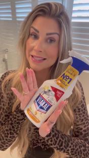 Woman holding a bottle of Viakal limescale remover.