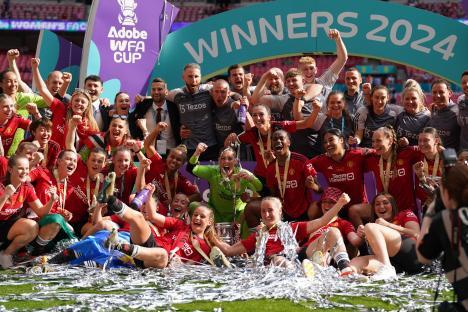 Manchester United women's soccer team celebrating their 2024 Adobe Women's FA Cup victory.