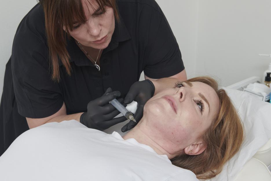 Woman receiving a Meta Cell Technology injection treatment in her neck.