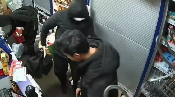 Surveillance footage of shoplifters stealing from a store.