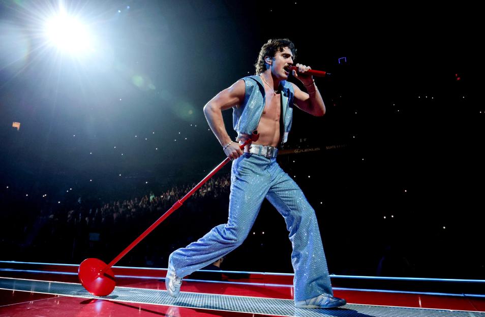 Benson Boone performs onstage during the American Heart World Tour in a glittery blue outfit.