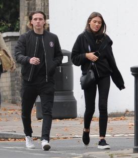 Brooklyn Beckham and a woman walking down the street.
