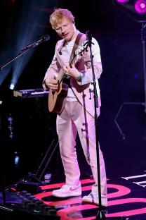 Ed Sheeran performing onstage with a guitar.