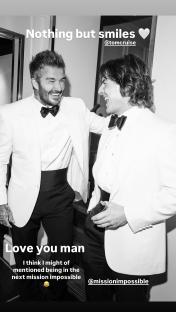 Black and white photo of David Beckham and Tom Cruise smiling in tuxedos.