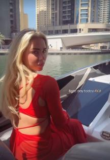 Woman in red dress on a boat.