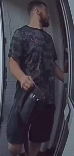 Man entering doorway carrying bag.