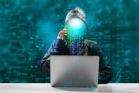 Illustration of a hooded figure using a laptop, with binary code cascading from their face.