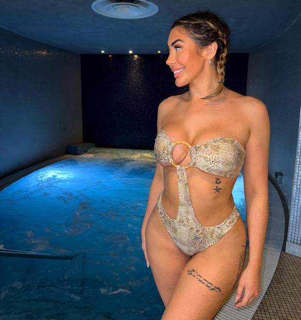 Chloe Ferry in a brown bikini by a hot tub.