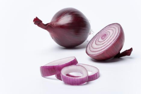 sliced red onions next to a whole red onion