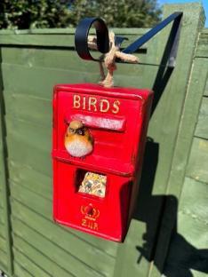 Red bird feeder shaped like a mailbox.