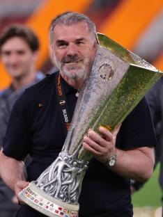 Ange Postecoglou holding the UEFA Europa League trophy.