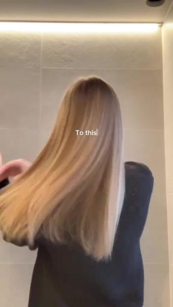 A woman with long, blonde hair being tossed back and forth, showing its length and volume.