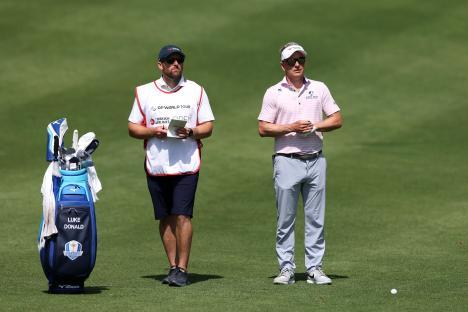 Luke Donald and his caddie on a golf course.