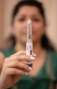 Woman's hands holding a Wegovy injection pen.