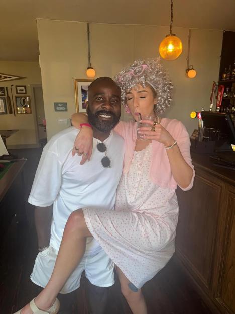 A man and woman in costume; the woman is dressed as an elderly person.