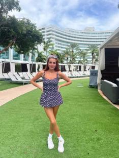 Woman in polka dot swimsuit at resort.