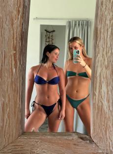 Two women in bikinis taking a selfie in a mirror.