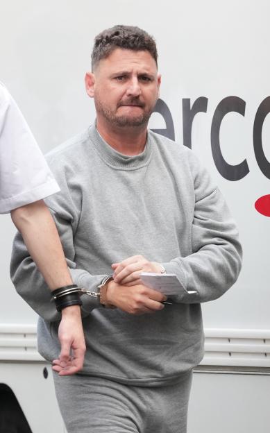 Arno Engels, a man accused of murder, appearing in court in handcuffs and a grey tracksuit.