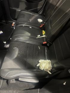 Messy backseat of a car.