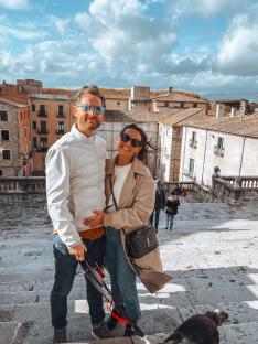 Emma Kemsley and her husband James on a stairway, with a town in the background.