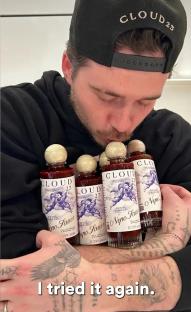 Man holding several bottles of Cloud23 Nepo Sauce.