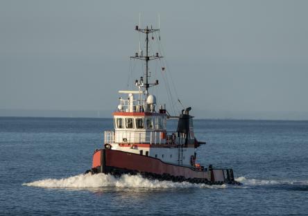 Red and white tugboat on the water.