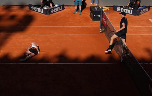Tennis player fallen on the court during a match.