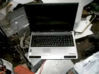 Laptop computer amidst electronic waste.