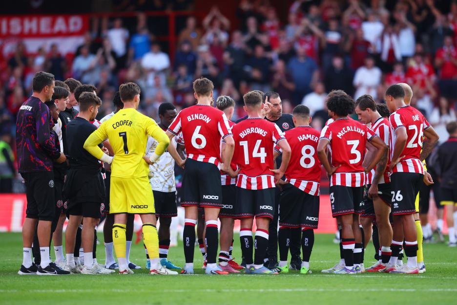 Sheffield United players listening attentively to their coach.