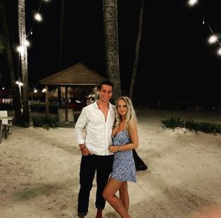 Couple standing on a beach at night.