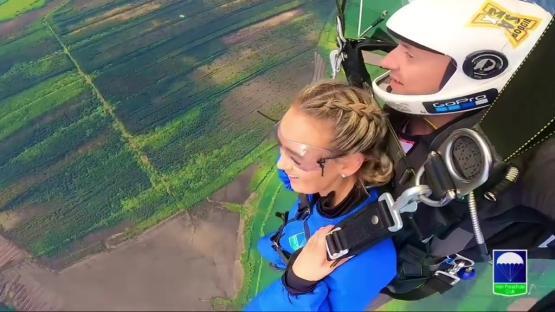 A woman skydiving, attached to an instructor.