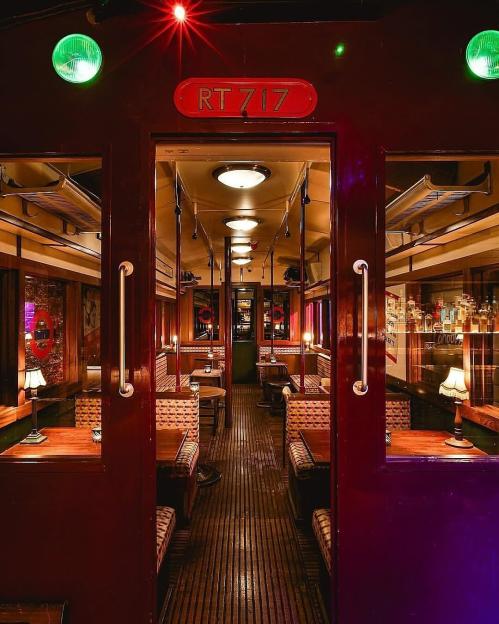 Interior view of the Cahoots Underground Restaurant, resembling a train car with booths and tables.