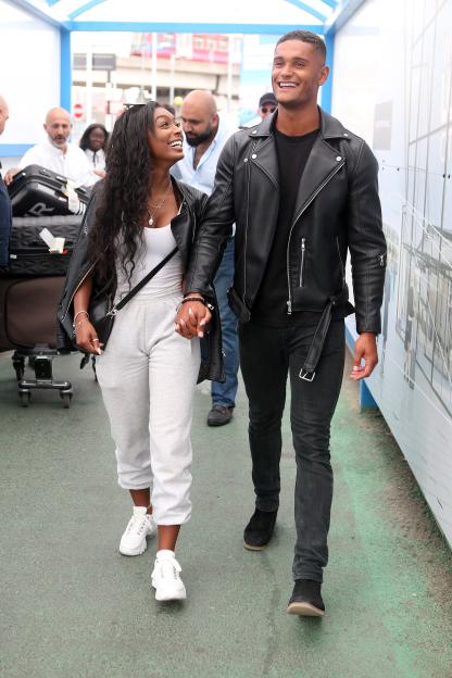 Jourdan Riane and Danny Williams holding hands and walking at an airport.