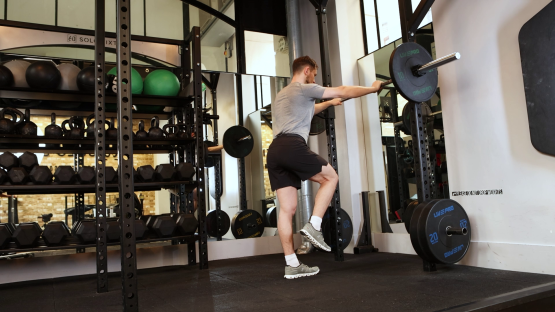Man performing a leg exercise in a gym.