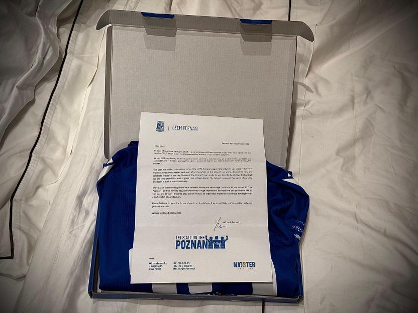 A blue and white Lech Poznań football jersey with a personalized letter from the club to Noel Gallagher.