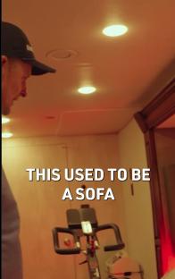 Man looking at stationary bike where a sofa used to be.