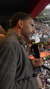 Rio Ferdinand at the Europa League final, holding a microphone.