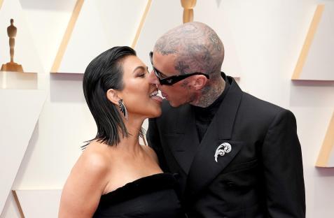 Kourtney Kardashian and Travis Barker kissing at the Academy Awards.